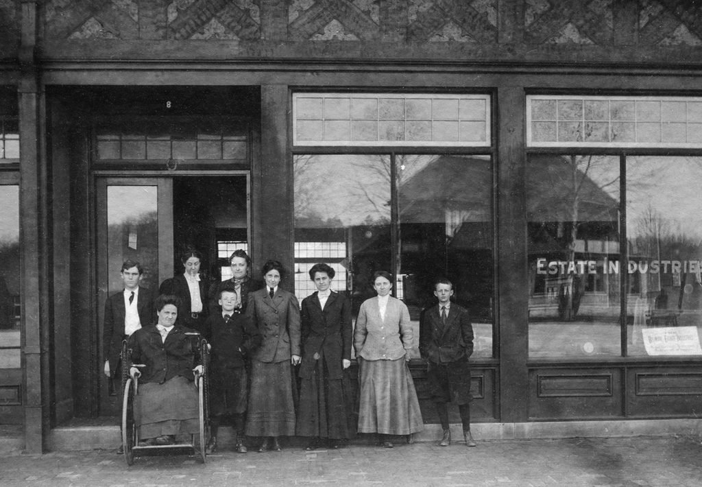 Archival photo (circa 1905) of the facade of Biltmore Estate Industries in Asheville, NC. Standing in the doorway, left to right, Charlotte Louise Yale and Eleanor Park Vance.