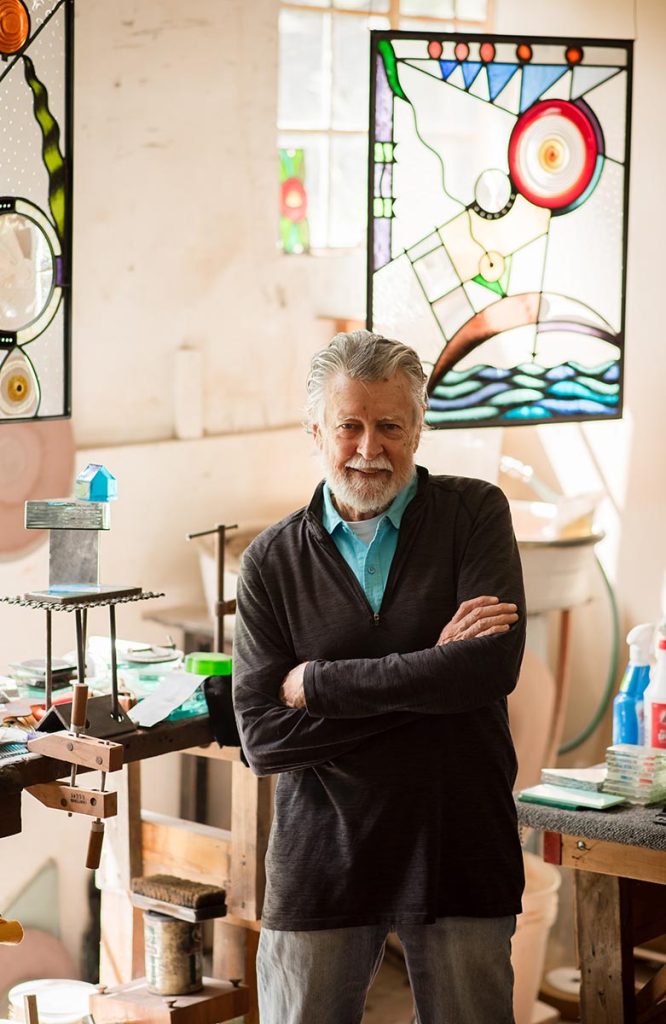 Artist Carl Powell posing in his Asheville studio in Grovewood Village.