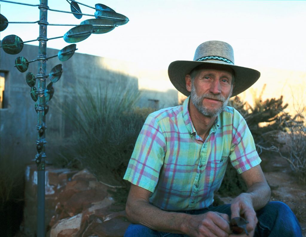 Utah artist Lyman Whitaker posing in front of his Wind Sculpture.