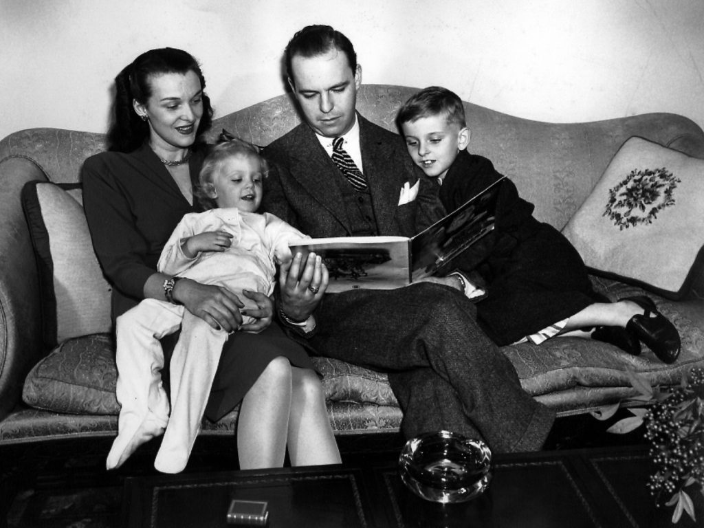 Fred Loring Seely and his wife, Evelyn Grove Seely, reading a story to their two children.