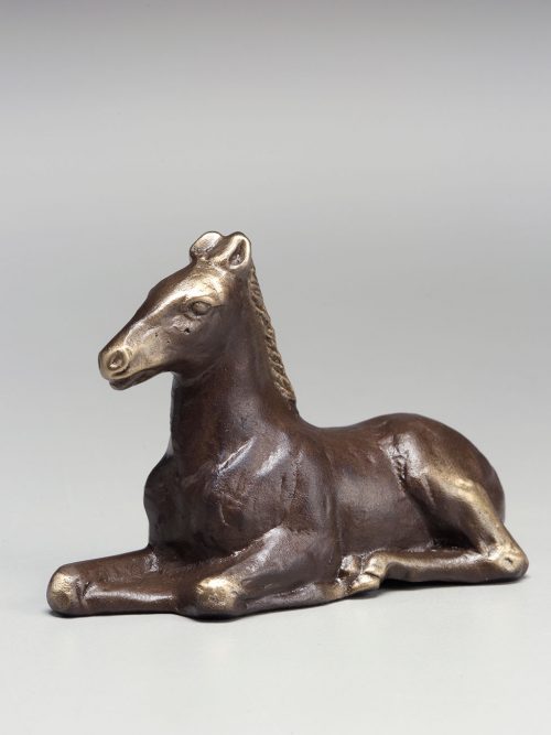 Reclining bronze pony sculpture by artist Scott Nelles.