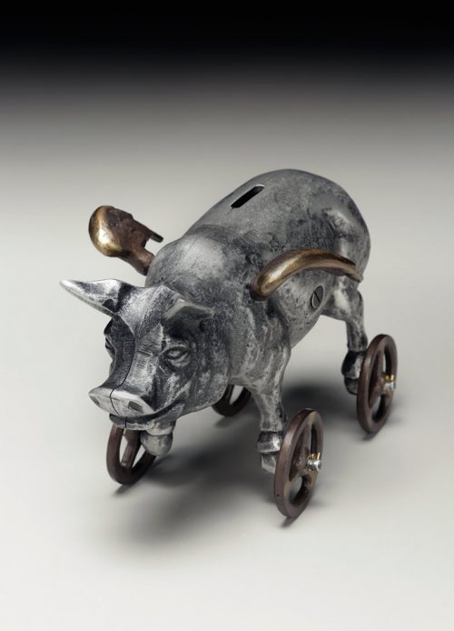 Top view of a metal flying pig coin bank by Scott Nelles.