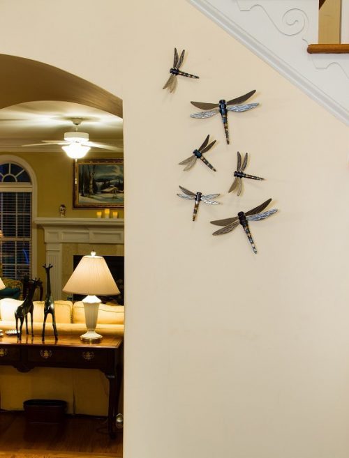 Display of dragonfly wall art by John Running in a home.