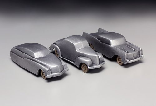 A grouping of three retro car sculptures by Scott Nelles.