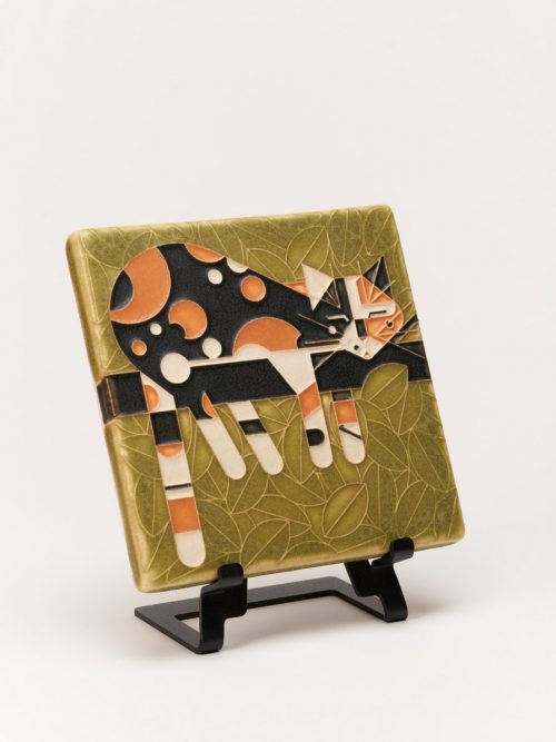 A ceramic art tile of a cat lying on a limb by Motawi Tileworks.