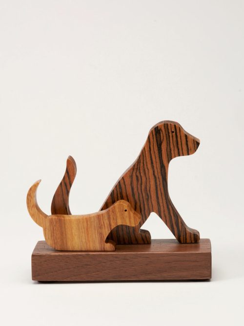 A small wooden sculpture of two dogs handcrafted by Jerry Krider.