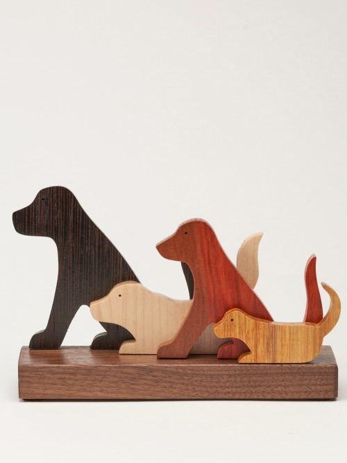 A small wooden sculpture of four dogs handmade by Jerry Krider.