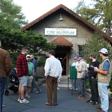 Men standing outside of the Estes-Winn Antique Car Museum in Asheville during the Cars and Coffee event.