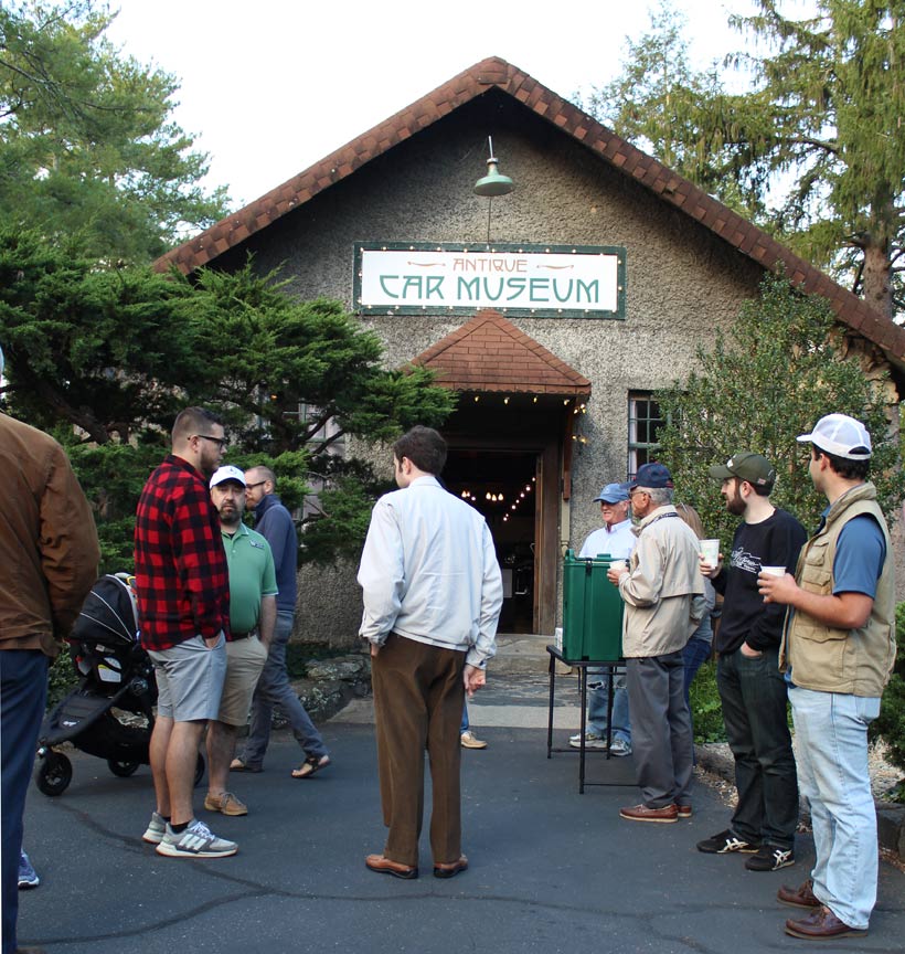 Men standing outside of the Estes-Winn Antique Car Museum in Asheville during the Cars and Coffee event.