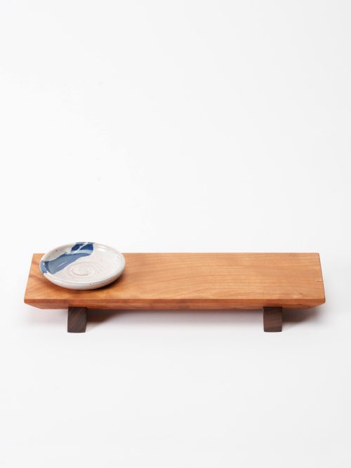 A handmade sushi board with a ceramic dipping bowl crafted in North Carolina by Sabbath-Day Woods.