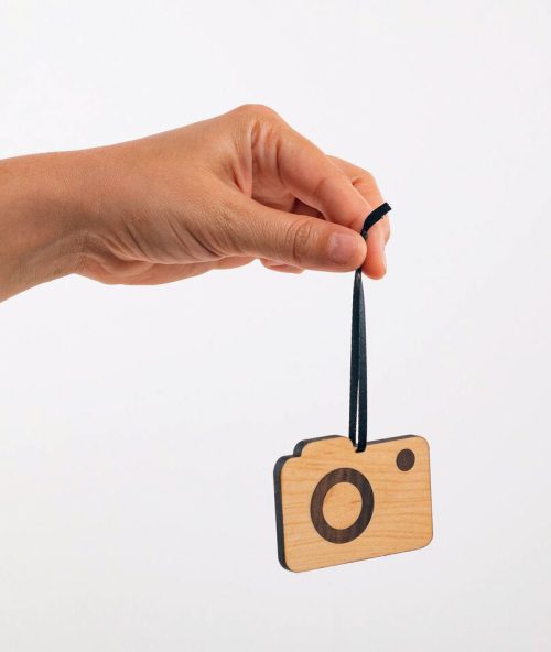 A small camera ornament handmade from walnut and maple by Collin Garrity.