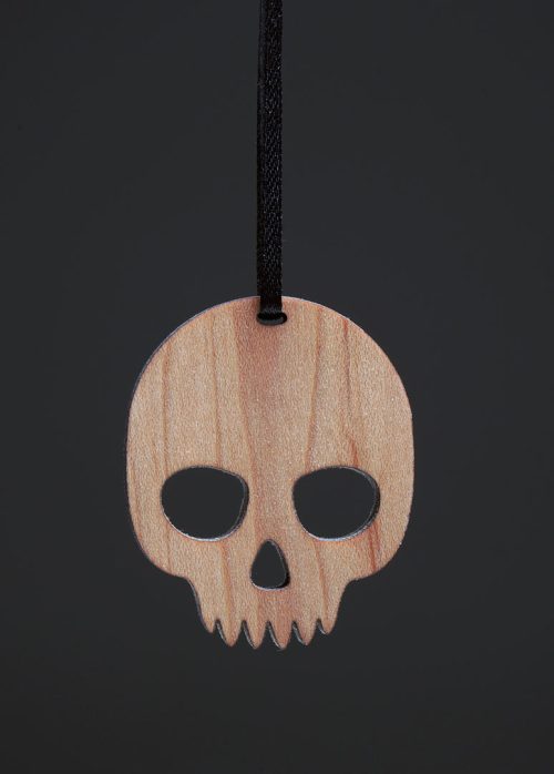 A skull ornament on a black background handmade from solid maple by Collin Garrity.