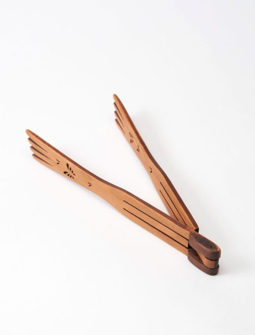 Small butterfly tongs in the open position, handcrafted from cherry wood by Moonspoon.