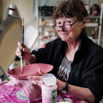 Ceramic artist Helen Purdum glazing pottery in her Grovewood Village studio.