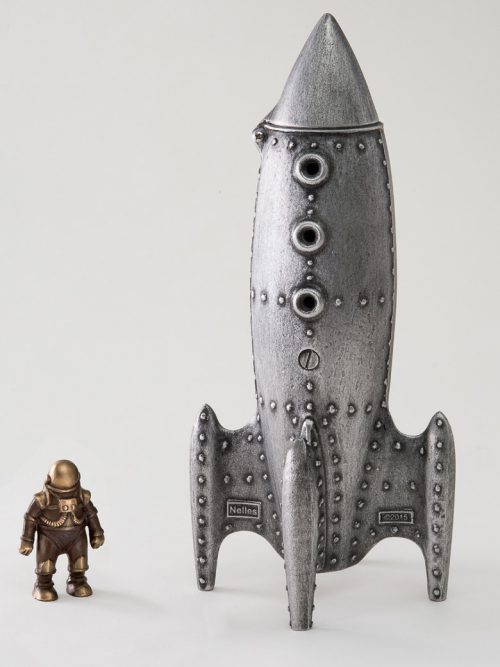 A cast aluminum and bronze sculpture by Scott Nelles of a moon rocket coin bank and spaceman.