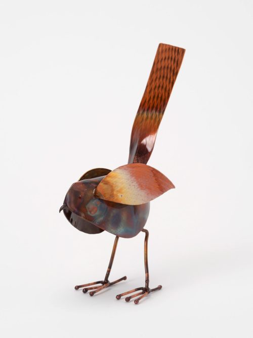 A small copper color metal bird sculpture by Haw Creek Forge.