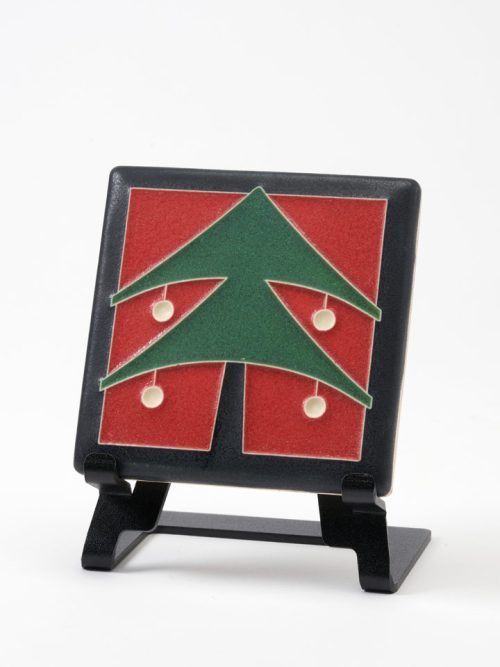 A ceramic art tile by Motawi Tileworks featuring a Christmas a green Christmas tree with a red background.