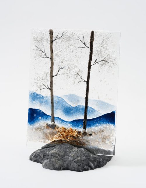 A mountain vista glass panel featuring winter trees by Amanda Taylor.