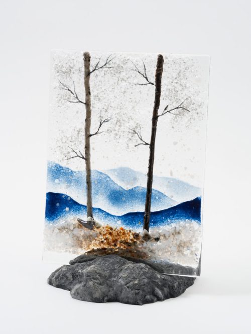 A mountain vista glass panel featuring winter trees by Amanda Taylor.