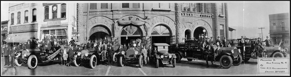 Photo of the 1922 Ashville Fire Department, Engine Number 2 at right. Chief A.L. Duckett stands beside the chief's car.
