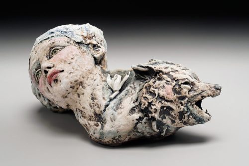 Stoneware clay and porcelain sculpture by Asia Mathis featuring a woman's head and a wolf.
