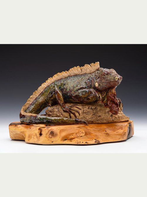 An iguana sculpture on a wooden base by artist Tina Curry.