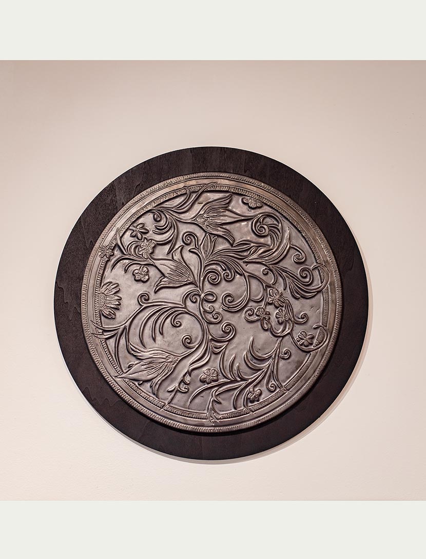 A botancial carved wall piece by artist Leslie Green Guilbault.