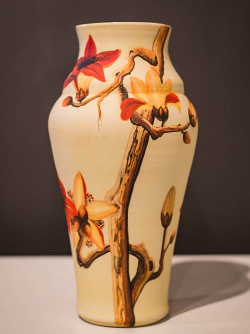 Wheel-thrown ceramic vase by Leslie Green Guilbault in warm cream, featuring a smooth surface and hand-painted branch and floral bud motif.