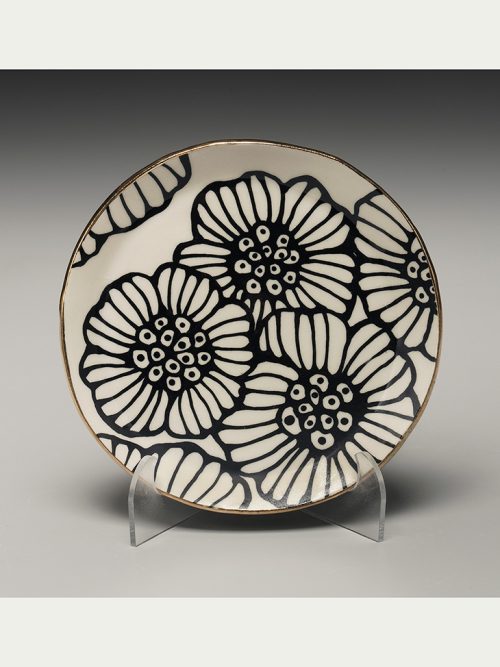 A gold rimmed round floral plate by Nicole Hsieh.