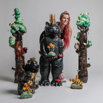 Artist Taylor Robenalt posed with her sculpture titled “Mama Bear and Cub Rising with Resilience”