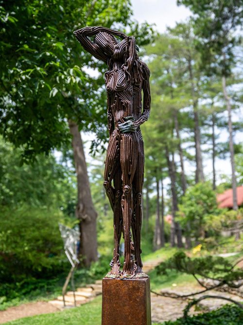 An outdoor sculpture of two figures by artist J. Aaron Alderman titled Like a Memory.