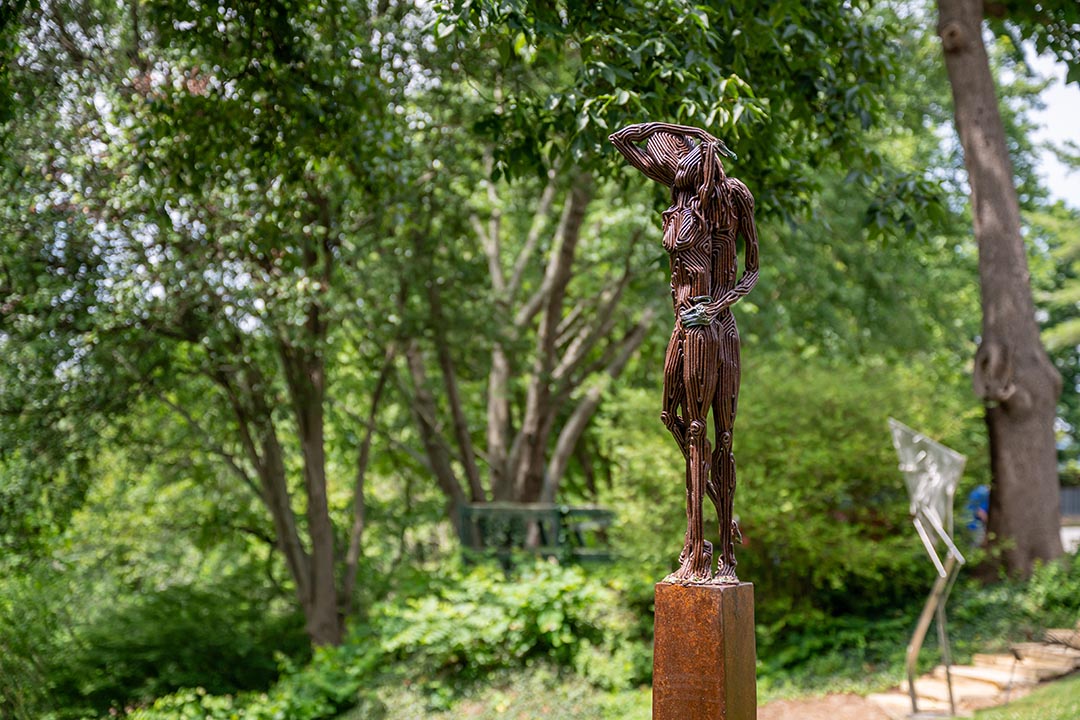 An outdoor sculpture of two figures by artist J. Aaron Alderman titled Like a Memory.