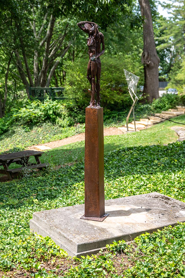 An outdoor sculpture of two figures by artist J. Aaron Alderman titled Like a Memory.